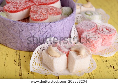 Present box with sweets on wooden background