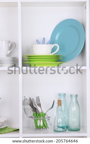 Kitchen utensils and tableware on beautiful white shelves