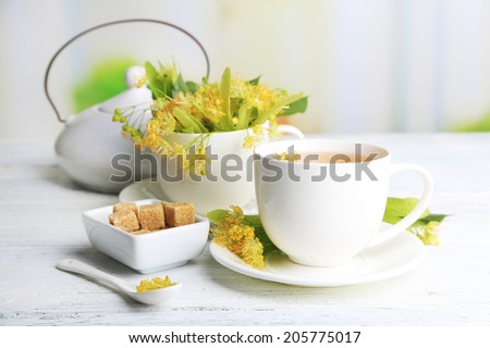 Tasty herbal tea with linden flowers on wooden table Tasty herbal tea with linden flowers on wooden table