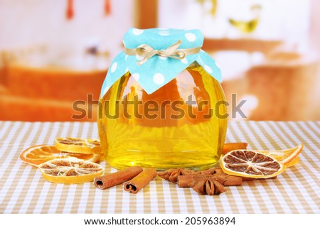 Jar of honey and dried lemon slices on bright background