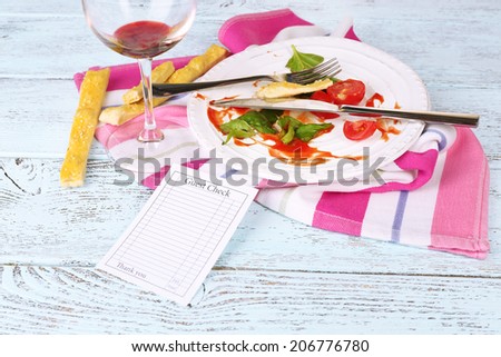 Check and remnants of food on table in restaurant