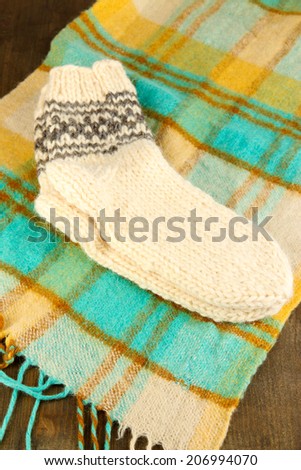 Warm knitted socks on plaid close-up