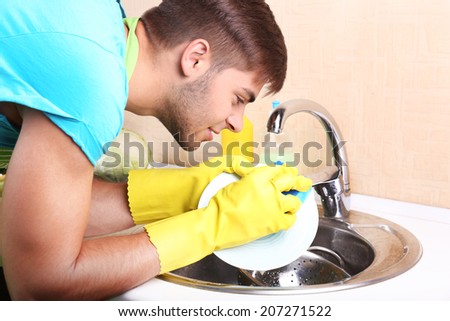 Man washing dish in kitchen