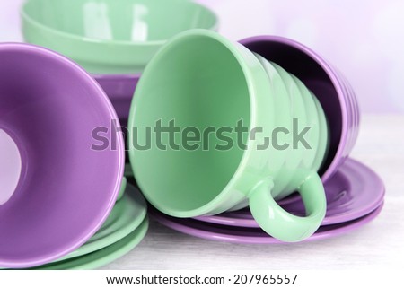 Bright dishes on table on bright background