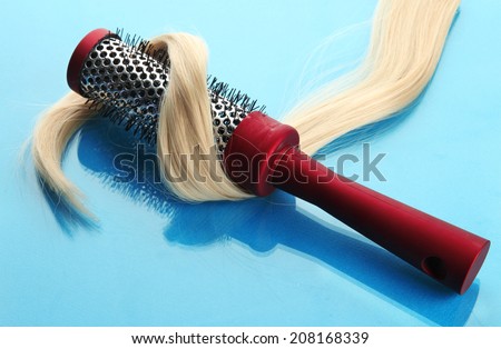 comb brush with hair,  on blue background