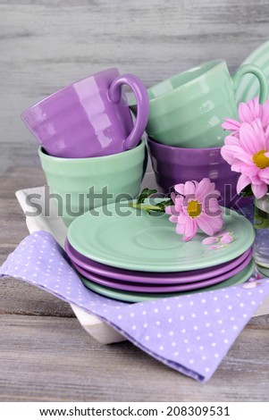 Bright dishes with flowers on wooden background
