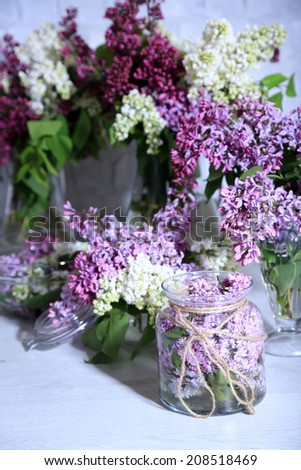 Beautiful lilac flowers in vase, on table, on light wall background