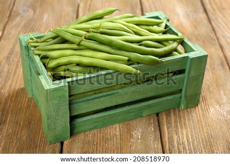 French beans in wooden box on table close-up
