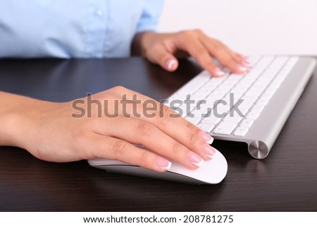 Female hand holding computer mouse, close-up