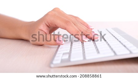 Female hands typing on keyboard, close-up, on light background
