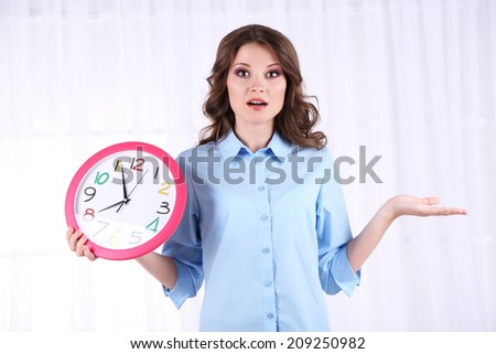 Young business woman with clock in room
