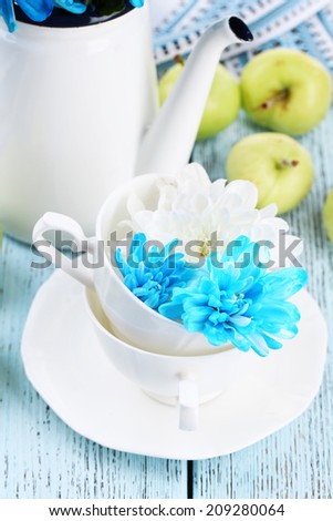 White and blue chrysanthemum with tableware on table close-up