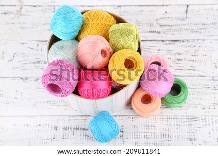 Clews of thread for hook knitting in box on wooden background
