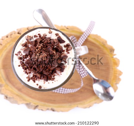 Yogurt, with chocolate cream, chopped chocolate and muesli served in glass jar, on wooden board, isolated on white