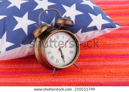 Metal clock on a dark blue pillow with white stars