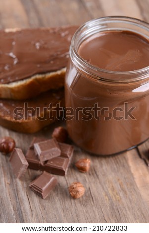 Sweet chocolate cream in jar on table close-up