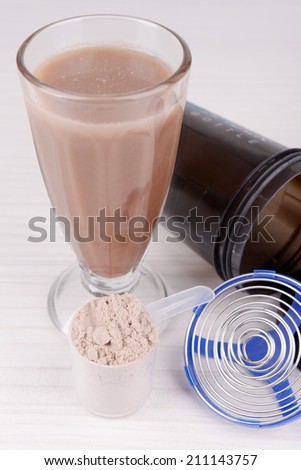 Whey protein powder with shake and plastic shaker on wooden background