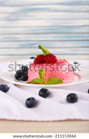 Round shaped cake with berries on plate on table cloth on table on light background
