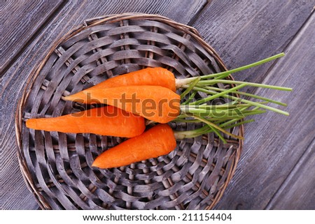 Carrots on round wooden mat on wooden background