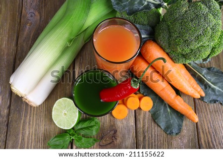 Fresh vegetable juice with spring onion, cauliflower carrot and chilly pepper on wooden background