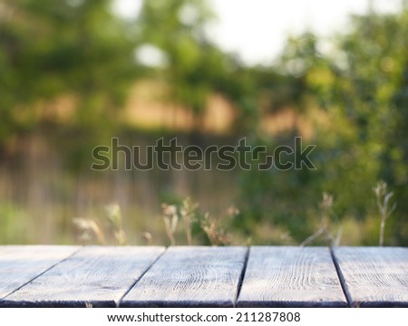 Wooden table with cloth on bright background