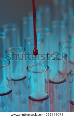 Test tubes with liquid and stick on grey background