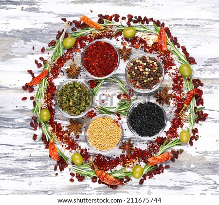 Spices with herbs and dried chilly pepper on wooden background