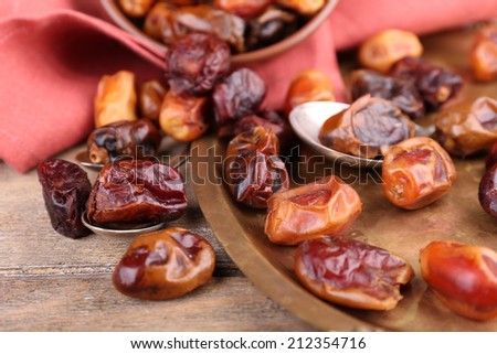 Tasty dates fruits on old metal tray, on wooden background