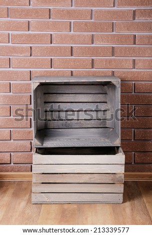 Rectangular wooden boxes on the floor in front of brick wall