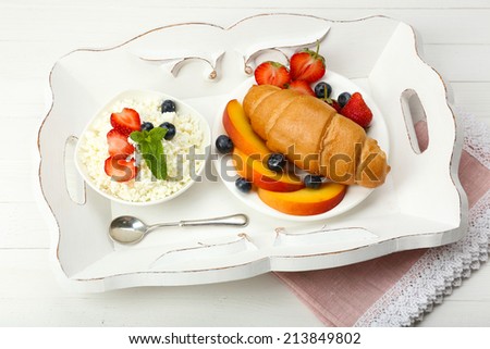 Delicious breakfast with croissant, cottage cheese and fruits