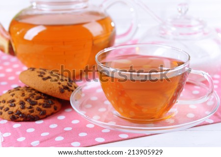 Teapot and cup of tea on table close-up