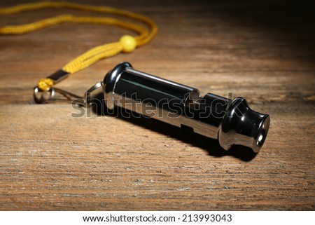 Sport metal whistle on wooden background