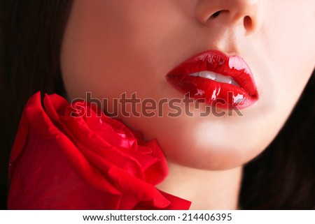 Woman\'s red lips and rose on dark background