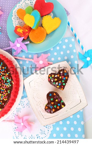 Delicious rainbow cakes on plates, on color wooden background