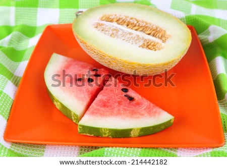 Water melon and melon on orange plate on  green tablecloth