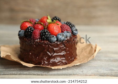 Tasty chocolate cake with different berries on wooden table