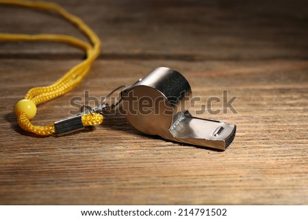 Sport metal whistle on wooden background