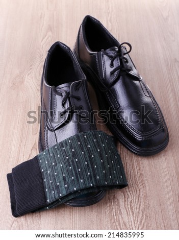 Black man\'s shoes and pair of socks on wooden background