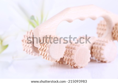 Wooden roller brush and lily on white background isolated