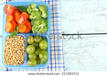 Tasty vegetarian food in plastic box on wooden table