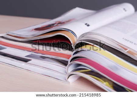 Magazines on wooden table on gray background