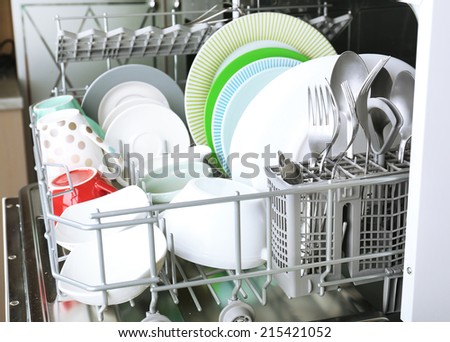 Open dishwasher with clean utensils in it