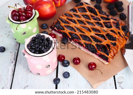 Sweet berries and berry tart on table close-up