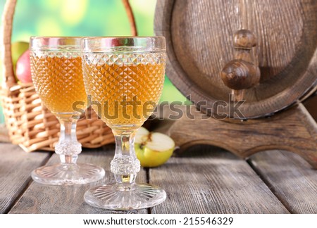 Still life with tasty apple cider and fresh apples, on nature background