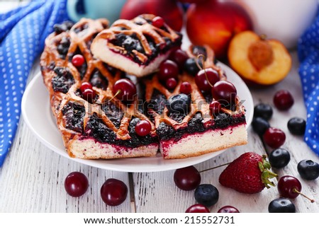 Sweet berry tart with berries on wooden table close-up