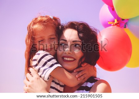 Happy mom and daughter with balloons