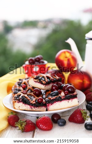 Sweet berry tart with berries on table on natural background