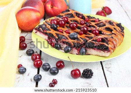 Sweet berries and berry tart on table close-up