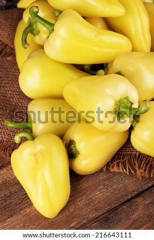 Yellow peppers on sackcloth on wooden table