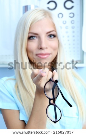 Medicine and vision concept - woman with eye chart